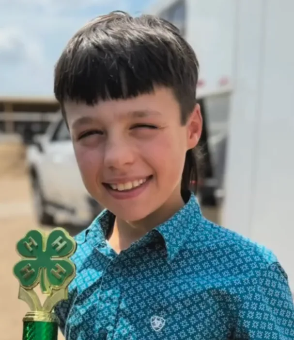 Portrait of Gus smiling with his 4H trophy